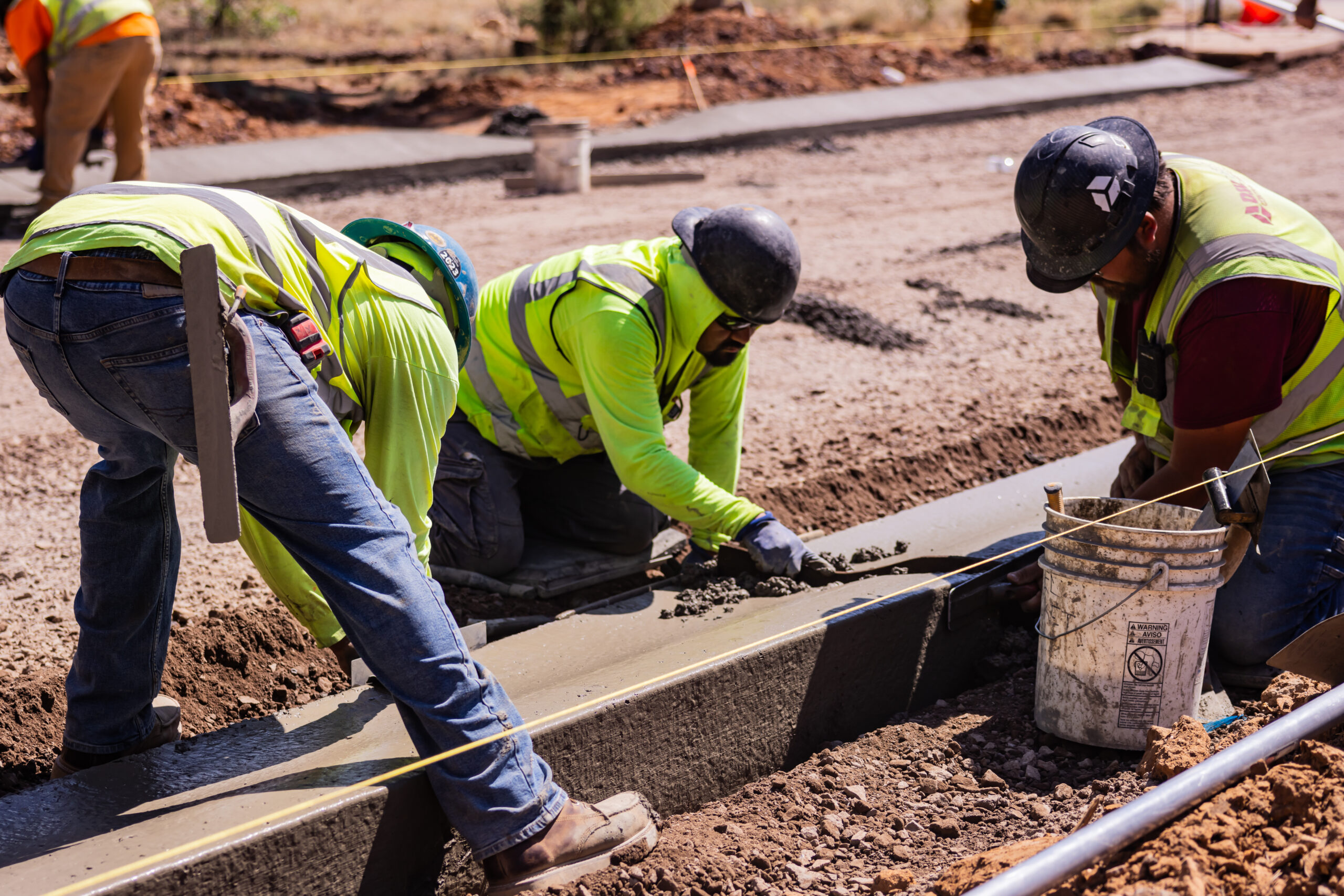 Workers finishing a cement curb